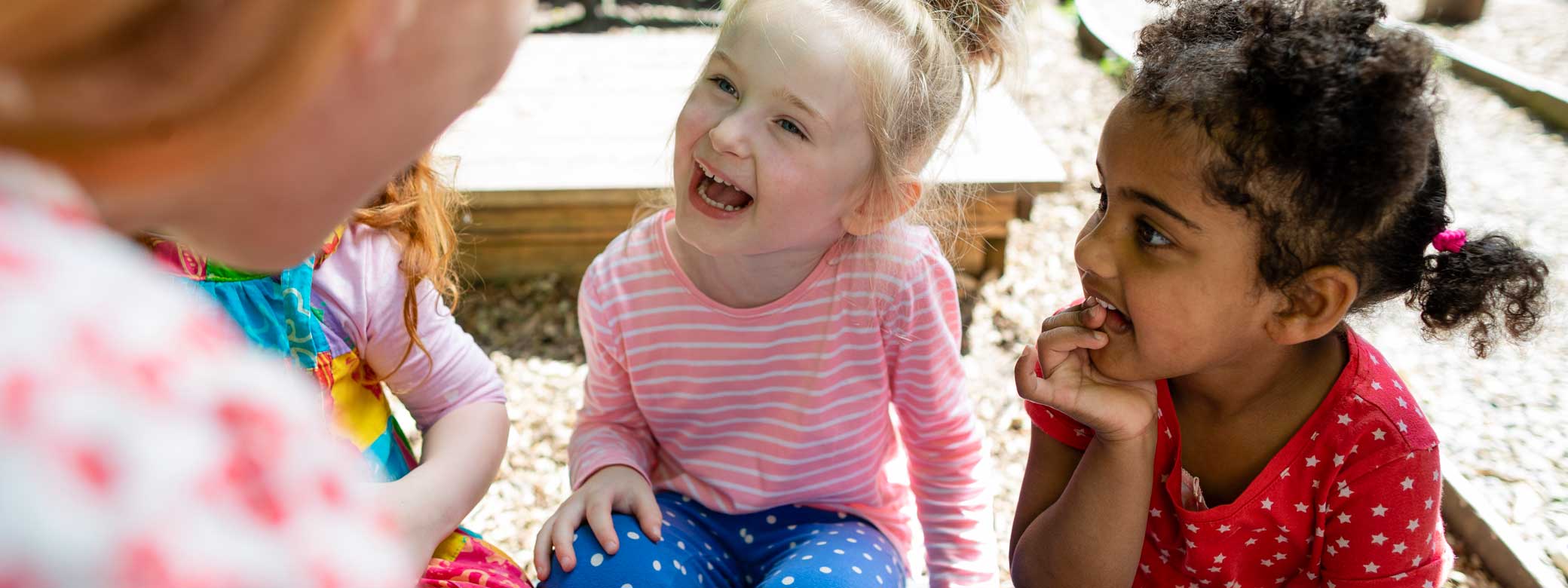 Kinder schauen zu Erzieherin und lachen