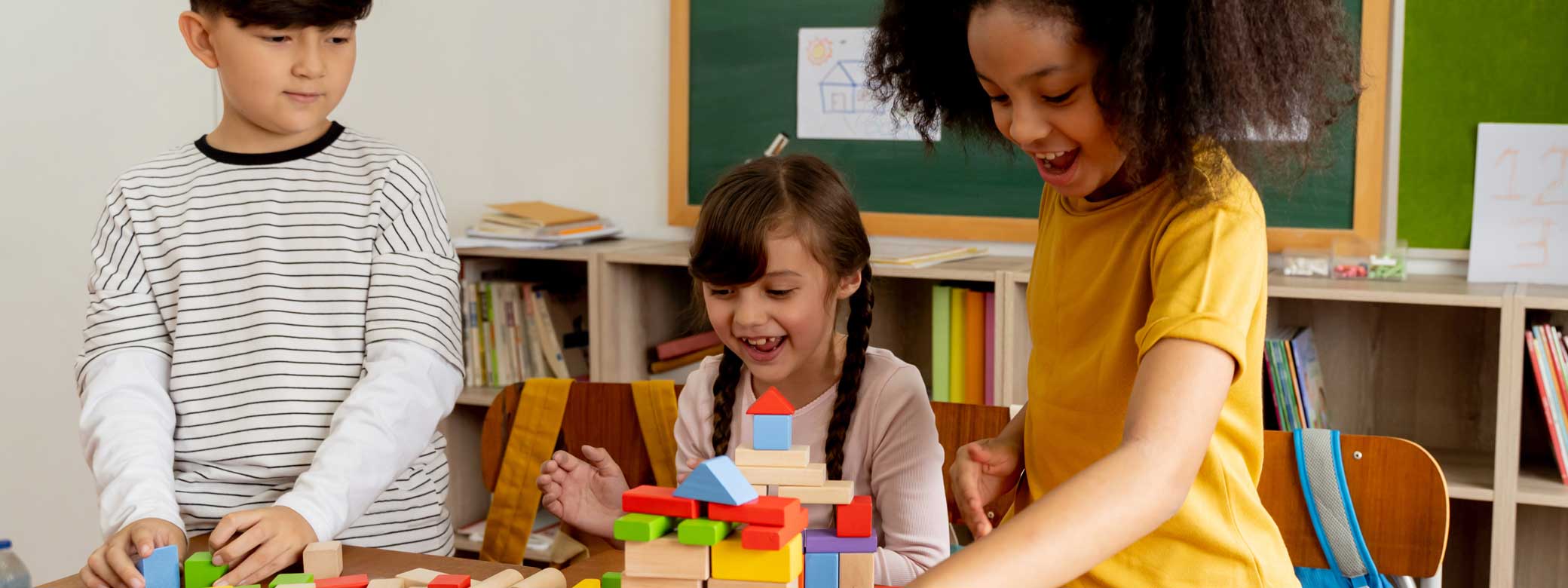 Drei Kinder spielen mit Holzbausteinen