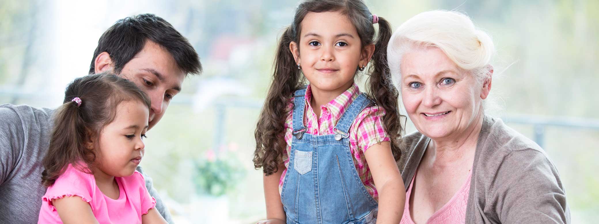 Kinder mit einer Erzieherin und einem Erzieher sitzen zusammen