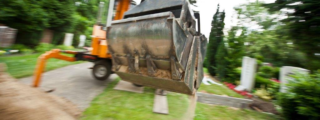 Baggerkralle mit Sand gefüllt auf dem Friedhof